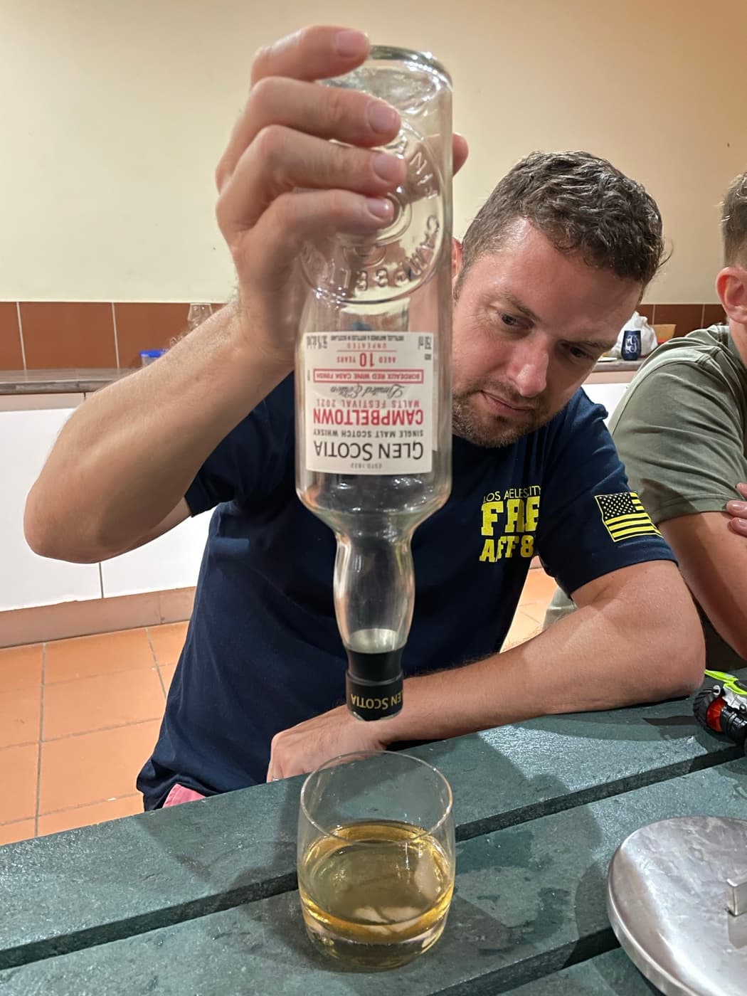 Club member showing off an empty Glen Scotia bottle